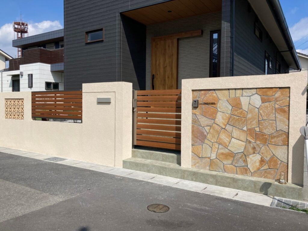 ダークな建物を包み込むやさしい色合いの外構